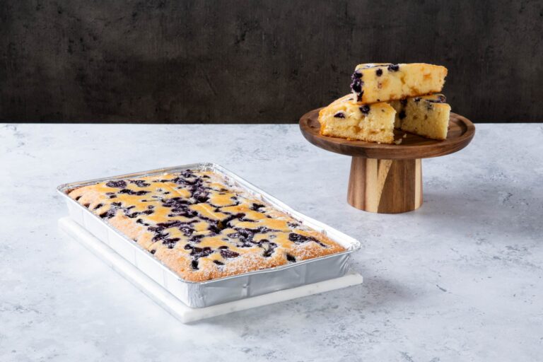 Blueberry crumble cake slices on a wooden cake stand and tray.