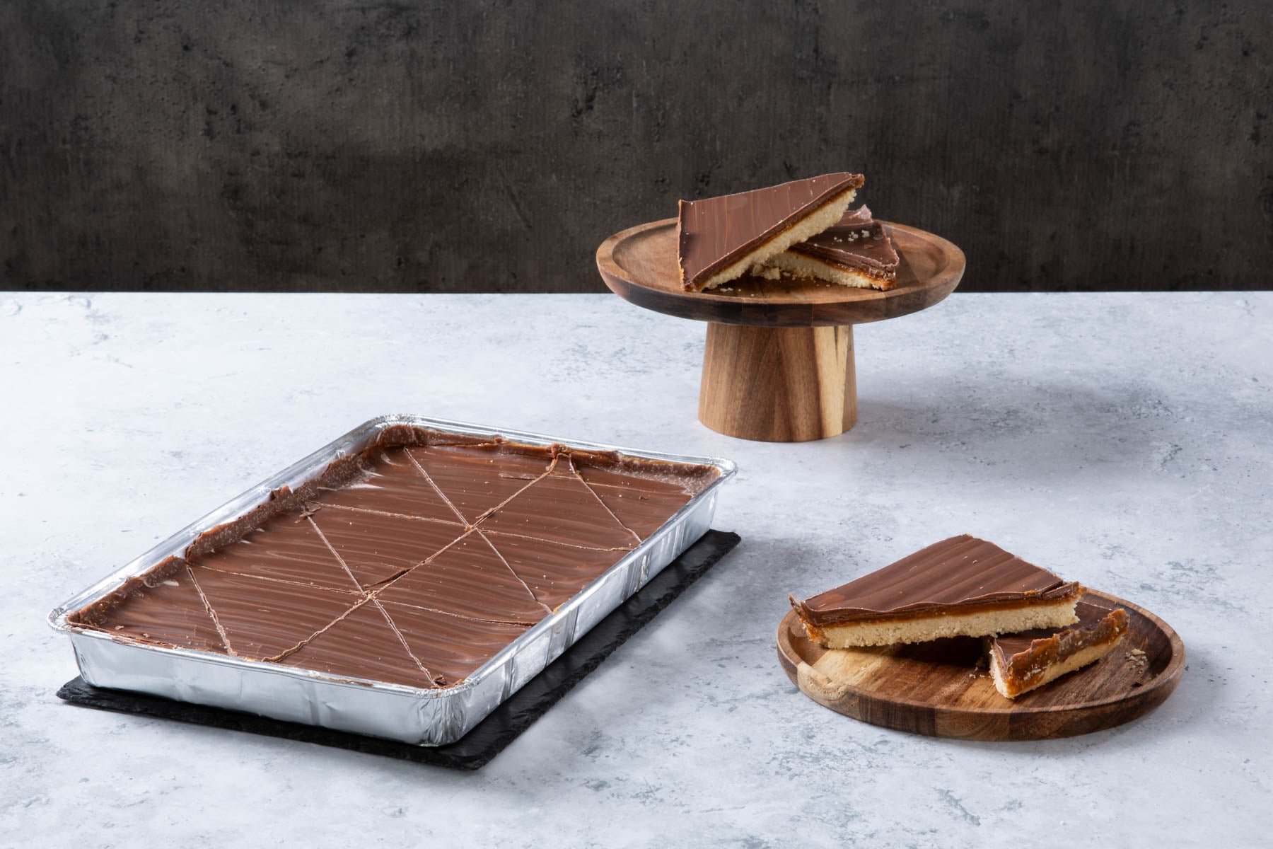 Chocolate caramel shortbread traybake with sliced pieces.