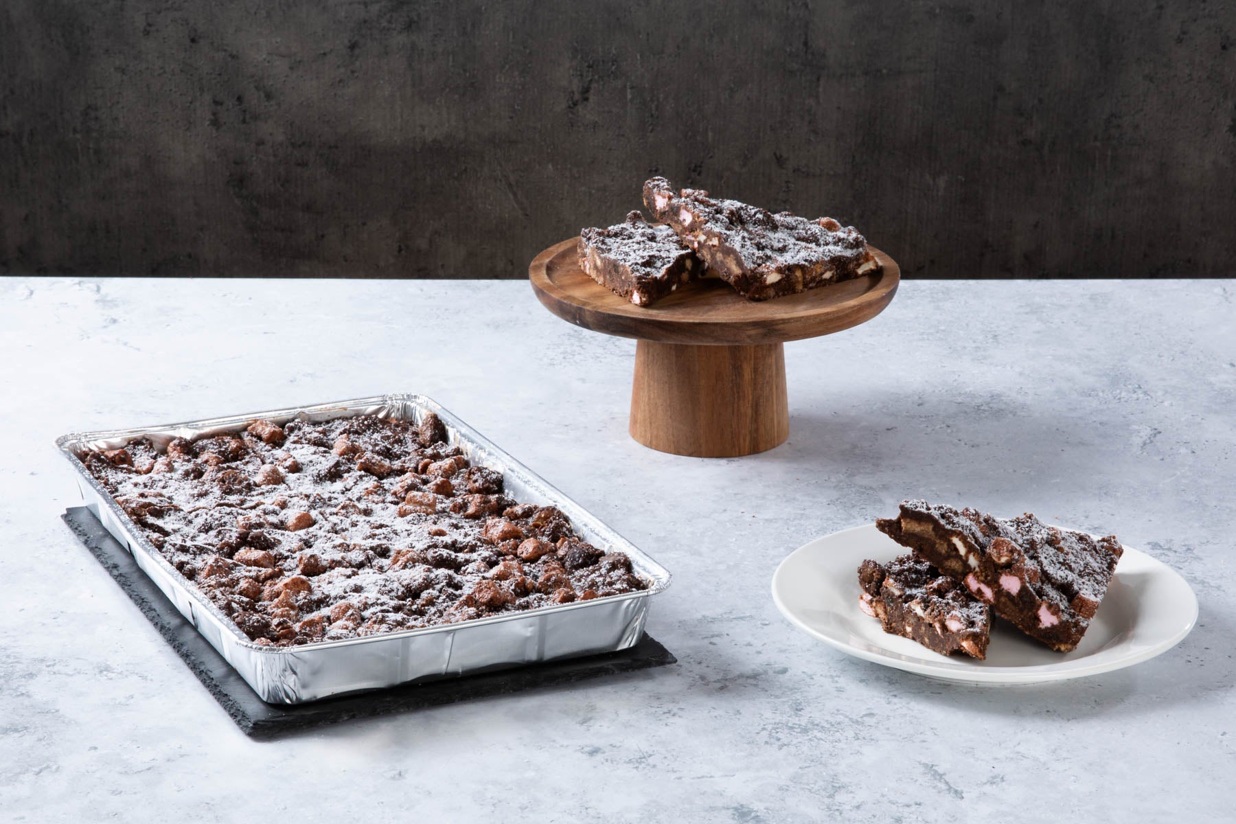 Chocolate rocky road traybake with sliced pieces and icing sugar.