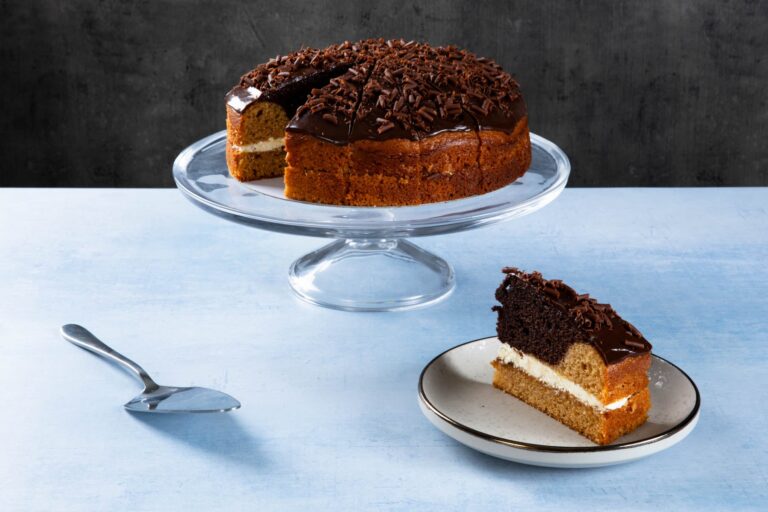 Lemon drizzle cake with lemon icing on a wooden board.
