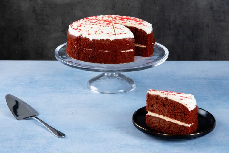 Chocolate cake with chocolate frosting and caramel topping on a wooden board.