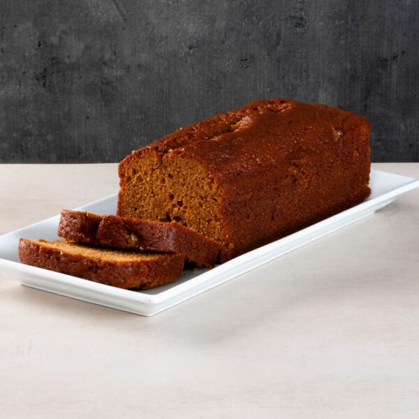 Sliced sticky toffee loaf cake on a white platter