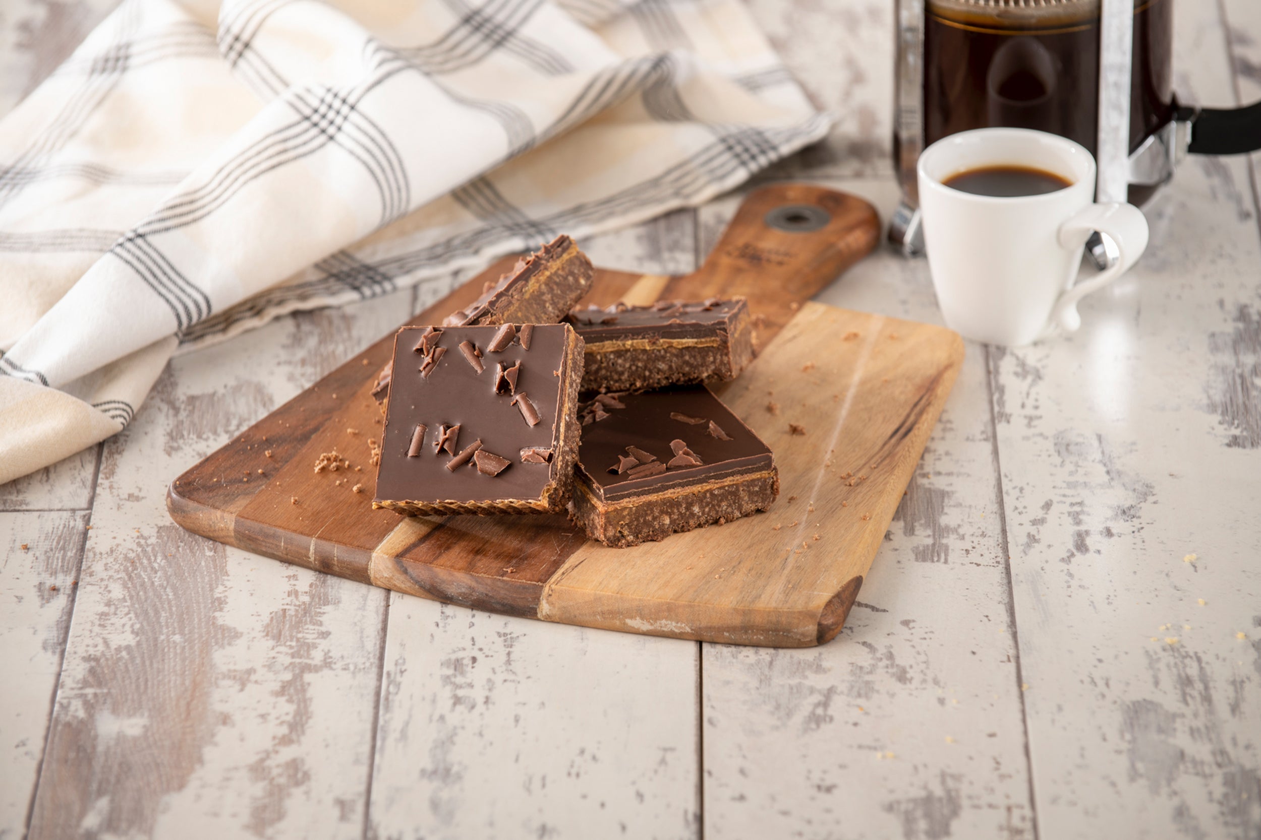 Chocolate caramel shortbread with chocolate topping on a wooden board.